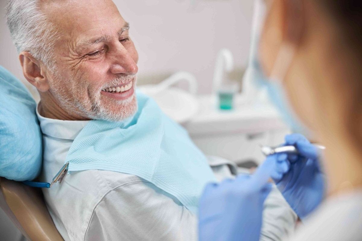 Senior man receiving dental care for dentures and missing teeth